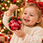 Child holding a personalized red Christmas jingle bell ornament